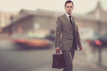 Man in classic grey suit with briefcase  outdoors