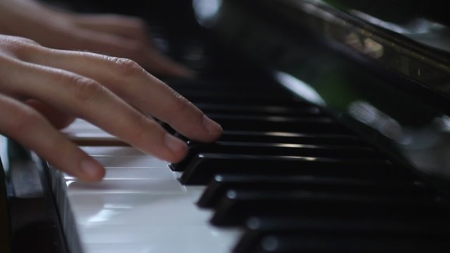 Hands of a woman playing piano with change of focus