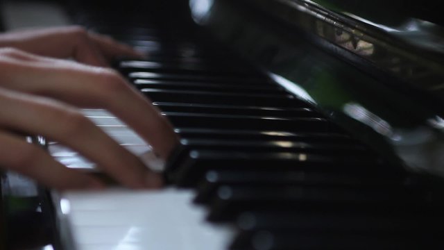 Hands of a woman playing piano with change of focus