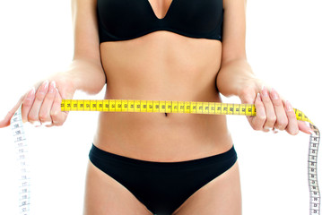 Slim woman in underwear holding measure tape. Isolated on white