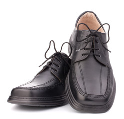 Black glossy man’s shoes with shoelaces