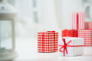 Gift boxes with xmas presents wrapped in red paper with ornament