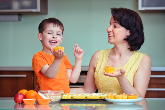 Smiling Young Mother And Son Baking Muffins