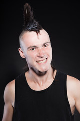 Punk rock man with mohawk haircut against black background.