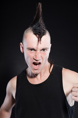 Fototapeta premium Punk rock man with mohawk haircut against black background.