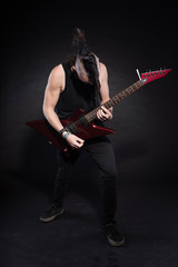 Fototapeta na wymiar Człowiek punk rock z czerwonym gitara elektryczna i irokezem na czarno.