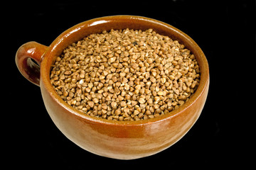 Buckwheat in ceramic bowl  on black