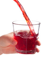 Female hand holding water glass with red liquid drink