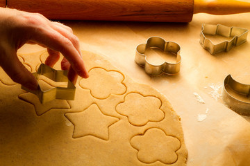 Cutting of homemade Christmas cookies on baking paper