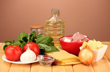 Lasagna ingredients on brown background