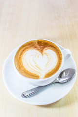 Cappuccino coffee with heart drawing in white cup