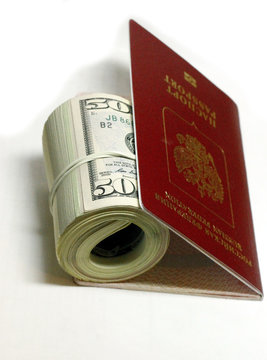 Stack of paper usa dollars inside the red passport