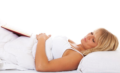 Attraktive Frau ist im Bett beim Lesen eingeschlafen