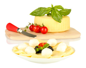 sliced mozzarella cheese with vegetables in the plate isolated