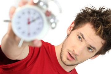 A frazzled man holding an alarm clock