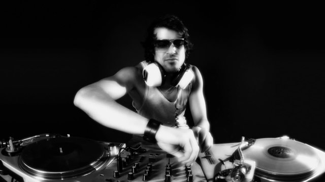 studio shoot of a cool male dj behind the turntables