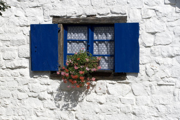 Fototapeta na wymiar Okno z niebieskimi okiennicami