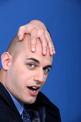 Obraz premium Bald businessman holding his head