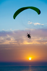 Silhouette of a paraglider at sunset