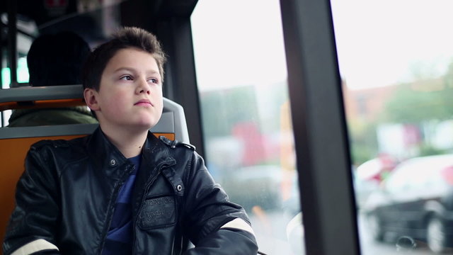 Sad, pensive boy riding bus in the city