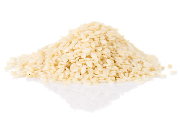 White sesame seeds heap on white reflective surface