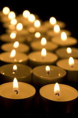 Fototapeta na wymiar Small candles in dark. Holiday/romance/religion concept
