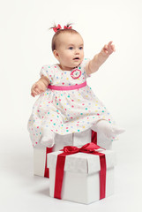 Adorable baby girl with two gift boxes