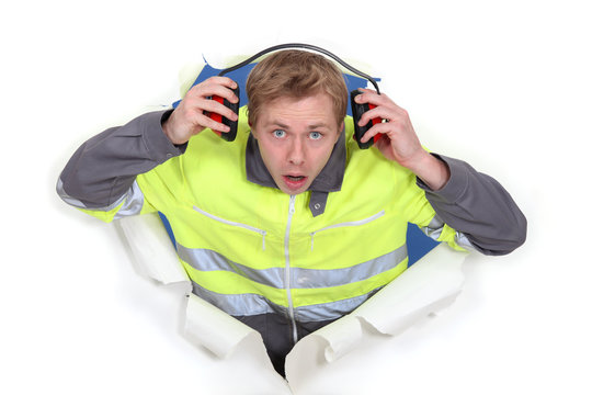 Man With Earmuffs Emerging From Poster