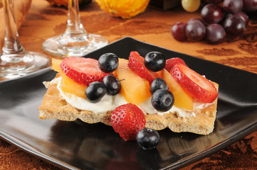 Berries and cream cheese on flatbread crackers