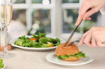 Female hand with  dinner on bright background
