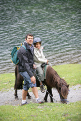 Man taking a child for a pony ride