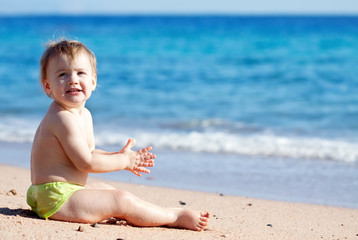 Fototapeta na wymiar Happy toddler on sand beach