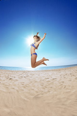 Fototapeta na wymiar Young beautiful woman on the sand by the sea