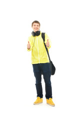 A happy teenage guy in modern clothes holding thumbs up
