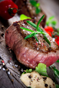 Bloody bbq steak with fresh herbs and tomatoes