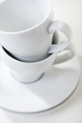 Weisse Kaffeetassen mit Untersetzer