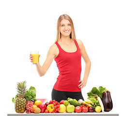 Female athlete refreshing with juice, behind a table full of foo