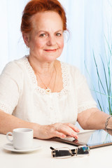 Smiling old woman with tablet pc