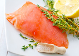Raw salmon on the white plate with thyme and salt