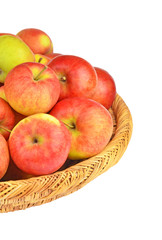 Red apple in a wattled basket, isolated on white background