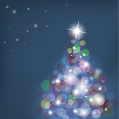 Christmas tree with blurred lights on blue background.