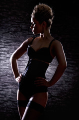 Fototapeta premium A young and sexy woman posing in dark erotic clothes