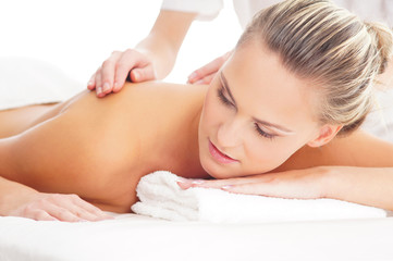 Obraz na płótnie Canvas A young woman laying on a spa massage procedure
