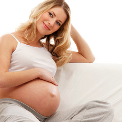 Fototapeta na wymiar Młodych blond kobieta w ciąży siedzą w zamkniętych ubrania