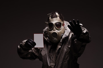 Man with a gas mask wearing hazmat suit, holding
