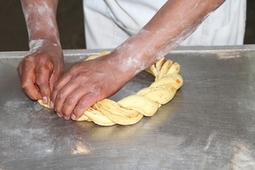 Bäckermeister beim Formen eines süßen Zopfes