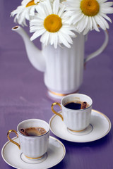 Beautiful chamomile and cup of coffee