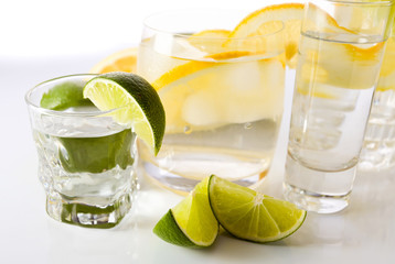 drinks with lemon and lime, shot on reflective white background.
