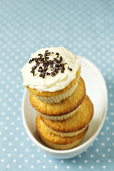 Stacked cupcakes in a bowl with frosting on top