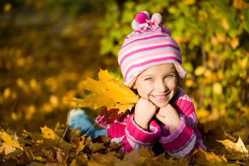 little girl lie on the leaves